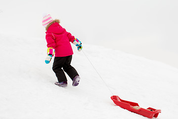 Image showing little girl with sled on snow hill in winter