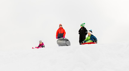 Image showing little kids sliding on sleds down hill in winter