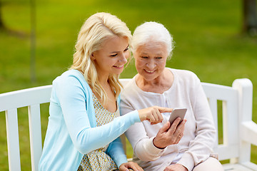 Image showing daughter and senior mother with smartphone at park