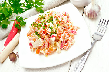 Image showing Salad of surimi and tomatoes with mayonnaise on wooden table
