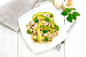 Image showing Salad of avocado and champignons on wooden board top