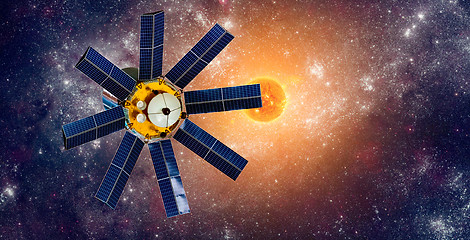 Image showing Space satellite orbiting the earth on a background star sun.