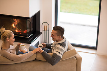 Image showing Young couple  in front of fireplace