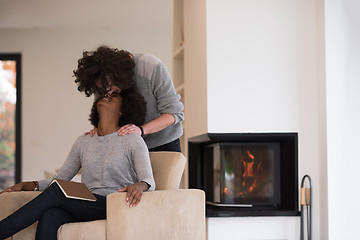 Image showing multiethnic couple hugging in front of fireplace