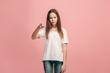 Image showing The teen girl pointing to you, half length closeup portrait on pink background.