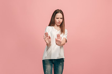 Image showing Doubtful pensive teen girl rejecting something against pink background