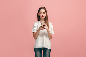 Image showing The happy teen girl standing and smiling against pink background.