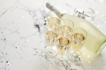 Image showing Champagne glasses and bottle placed on white marble background