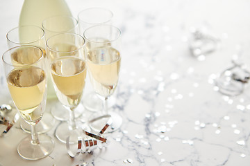 Image showing Champagne glasses and bottle placed on white marble background