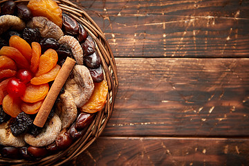 Image showing Mix of dried fruits in a small wicker basket on wooden table