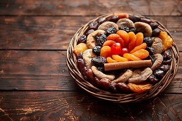 Image showing Mix of dried fruits in a small wicker basket on wooden table