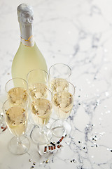 Image showing Champagne glasses and bottle placed on white marble background