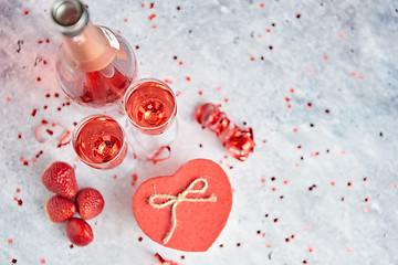 Image showing Bottle of rose champagne, glasses with fresh strawberries and heart shaped gift