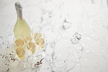 Image showing Champagne glasses and bottle placed on white marble background