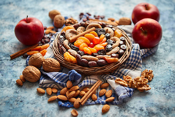 Image showing Composition of dried fruits and nuts in small wicker bowl placed on stone table