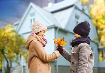 Image showing kids with autumn maple leaves over house outdoors