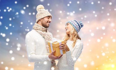 Image showing smiling couple in winter clothes with gift box