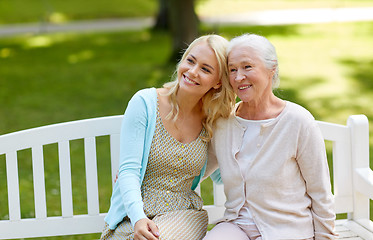 Image showing daughter with senior mother hugging on park bench