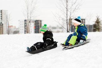 Image showing kids sliding on sleds down snow hill in winter