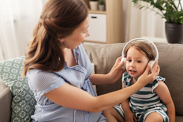 Image showing pregnant mother and little daughter in headphones