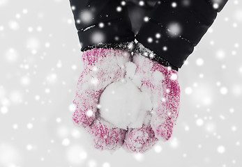 Image showing close up of woman holding snowball outdoors