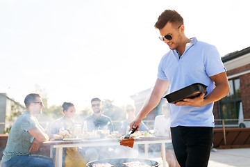 Image showing man cooking meat on bbq at rooftop party