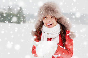 Image showing happy woman with snow in winter fur hat outdoors