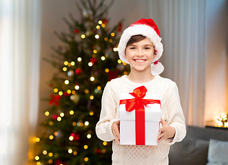 Image showing happy boy in santa hat with gift box on christmas