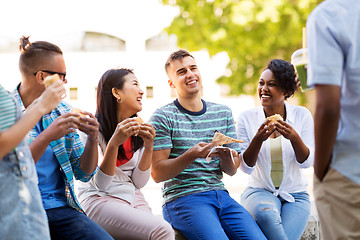 Image showing friends eating pizza and sandwiches in park