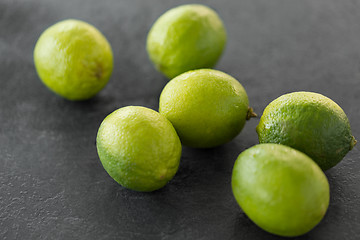 Image showing close up of whole limes on slate table top