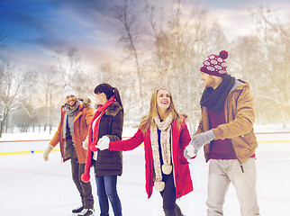 Image showing happy friends on skating rink outdoors