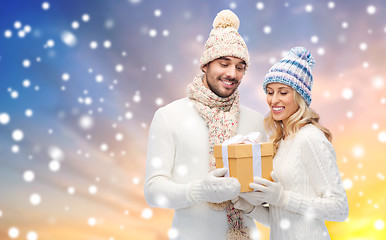 Image showing smiling couple in winter clothes with gift box