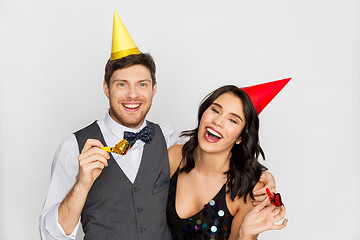 Image showing happy couple with party blowers having fun