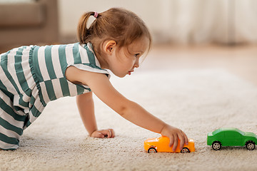 Image showing happy baby girl playing with toy car at home