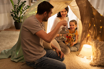 Image showing happy family playing in kids tent at night at home