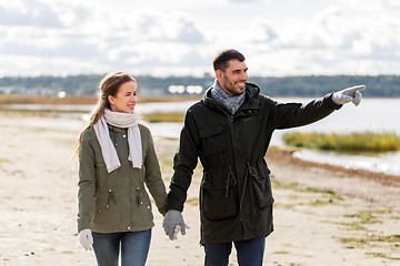 Image showing couple walking along autumn beach