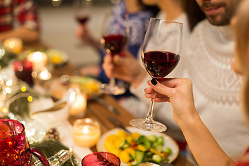 Image showing close up of friends drinking red wine on christmas