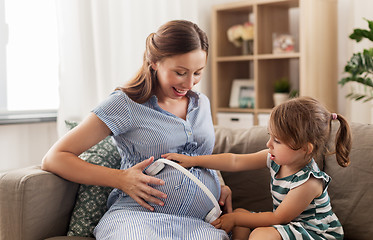 Image showing pregnant mother and little girl with headphones