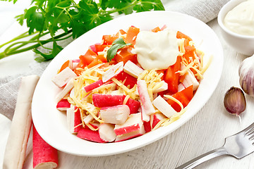 Image showing Salad of surimi and tomatoes on wooden board