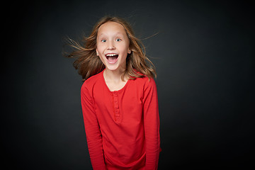 Image showing Happy girl looking with widely opened eyes and toothy smile