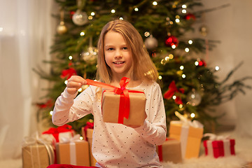 Image showing smiling girl with christmas gift at home