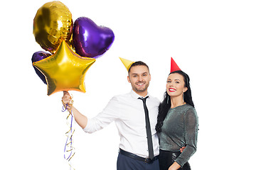 Image showing happy couple with party caps and balloons