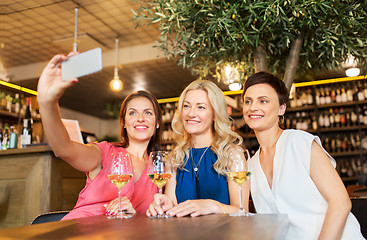 Image showing women taking selfie by smartphone at wine bar