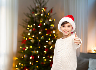 Image showing happy boy in santa hat showing thumbs up