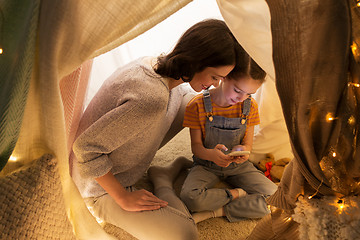 Image showing happy family with smartphone in kids tent at home