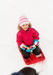 Image showing happy little girl on sled outdoors in winter