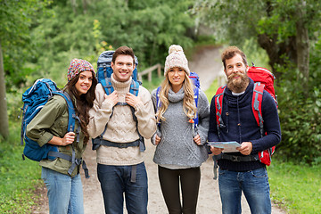 Image showing friends or travelers hiking with backpacks and map