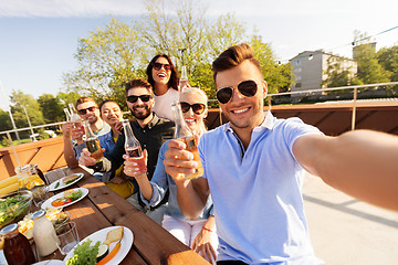 Image showing happy friends taking selfie at rooftop party