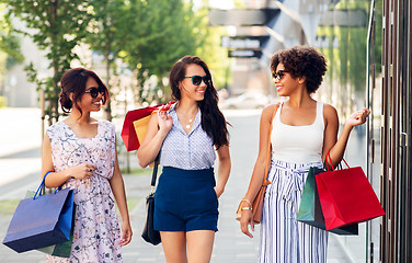 Image showing happy women with shopping bags walking in city