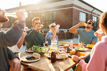 Image showing happy friends with drinks or bbq party on rooftop